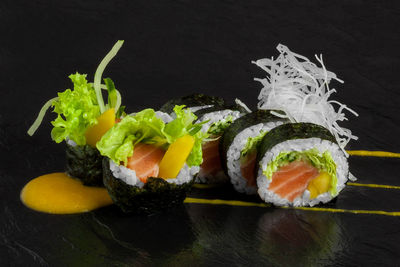 Close-up of sushi over black background