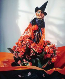 Close up of witch in red flower arrangement