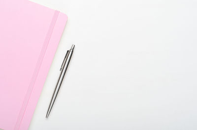 High angle view of pink pencils over white background