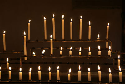 Many candles with flames during religion mass in the church