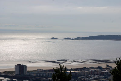 High angle view of city by sea against sky