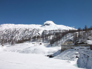 Scenic view of snowcapped mountains against clear blue sky