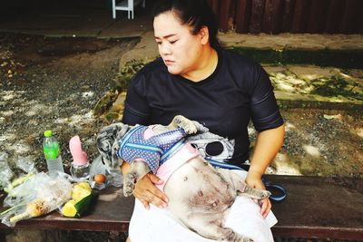 Woman with dog sitting outdoors