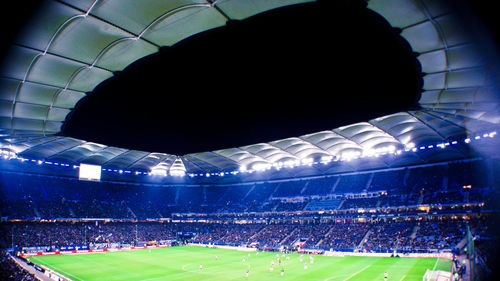 Low angle view of soccer field against blue sky