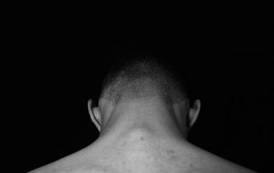 Close-up portrait of a man against black background