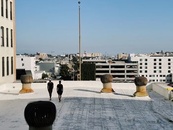 Rear view of people in city against clear sky