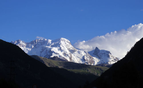 Scenic view of snowcapped mountains against blue sky