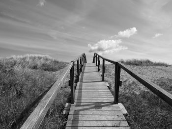 Pier on footbridge against sky