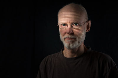 Portrait of senior man against black background