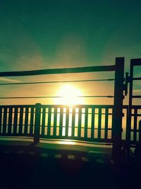 Illuminated railing against clear sky during sunset