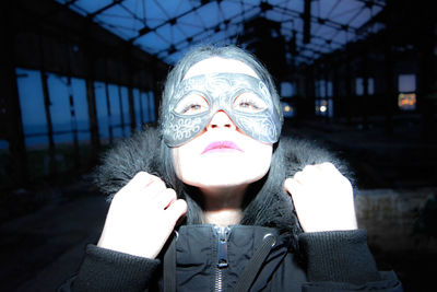 Close-up portrait of woman in mask at night