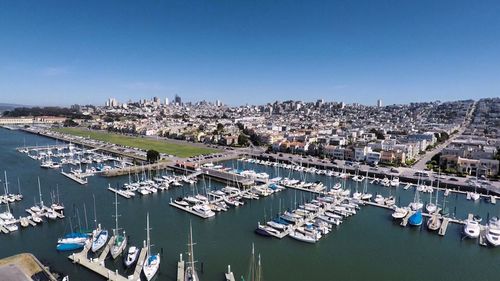 High angle view of boats moored in sea against clear blue sky