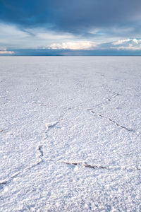 Snow covered land against sky