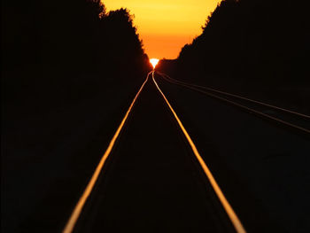 View of railroad tracks against sky at sunset