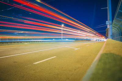 Light trails on road against sky at night