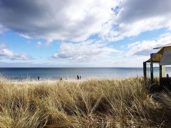 Scenic view of beach against cloudy sky