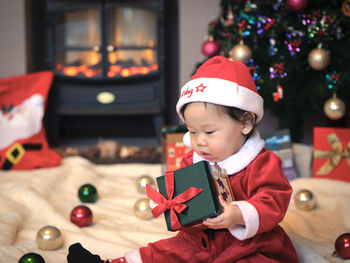 Cute baby girl with christmas gift at home