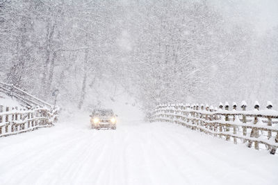 Car on snow covered road during snowfall