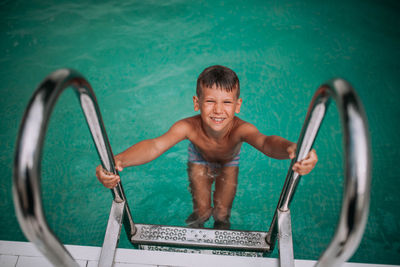 High angle view of smiling boy in swimming pool