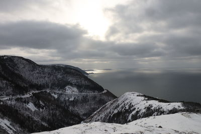 Scenic view of snowcapped mountains against sky and ocean. cabot trail, cape breton highlands np