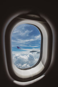 View of cloudy sky seen through airplane window