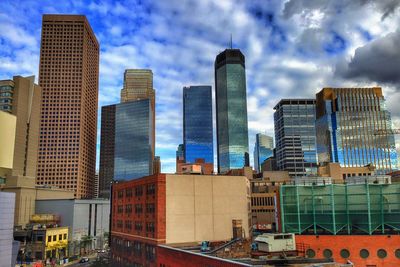 View of modern buildings against cloudy sky