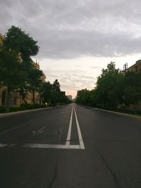 Road by trees against sky