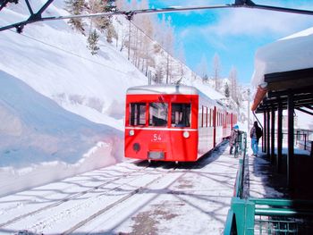 Red train on railroad track in winter