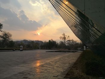 Road by street against sky during sunset