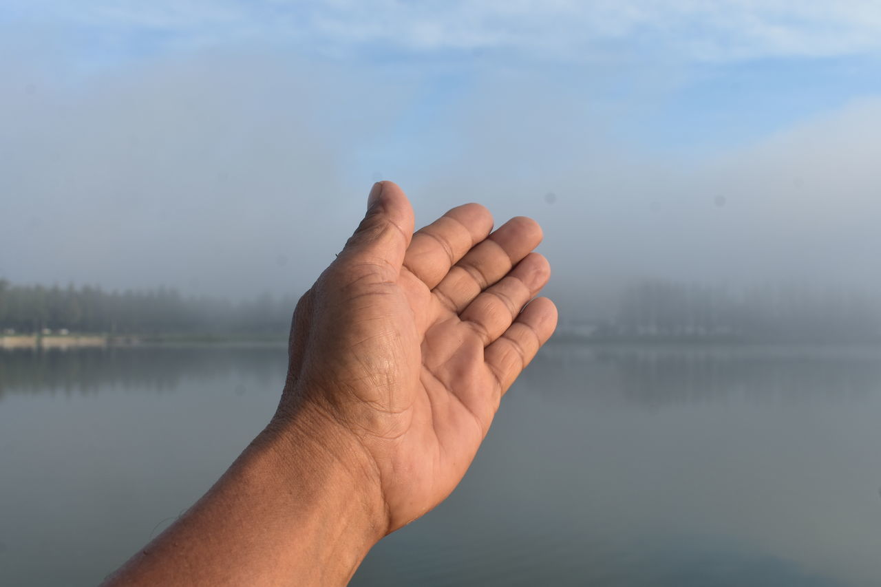 hand, water, lake, one person, nature, reflection, sky, tranquility, tranquil scene, beauty in nature, adult, finger, men, limb, personal perspective, lifestyles, morning, day, outdoors, cloud