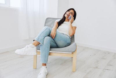 Young woman sitting on sofa at home