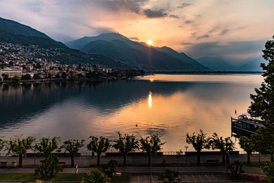 Scenic view of lake and mountains against sky at sunset