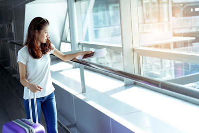 Full length of woman standing by window