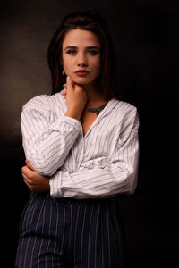 Portrait of a beautiful young woman over black background