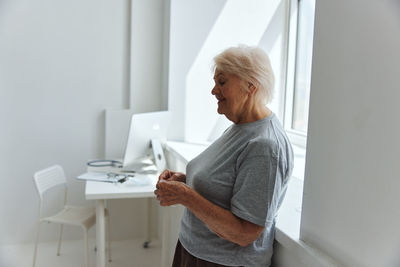 Side view of senior woman standing at hospital