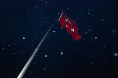 Close-up of flag against sky at night