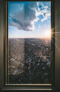 Aerial view of city buildings seen through glass window