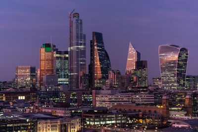 Illuminated buildings in city against sky