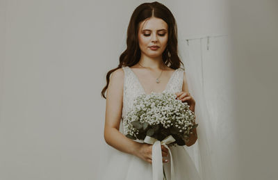 Portrait of a beautiful caucasian bride with a bouquet of boutonnieres.