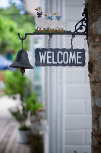 Welcome sign with bell hanging on tree