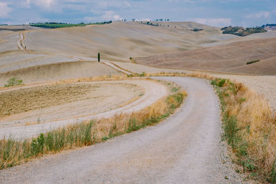 Road amidst field against sky