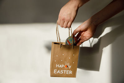 Cropped hand of woman holding gift box on table