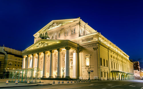 Low angle view of illuminated building against blue sky