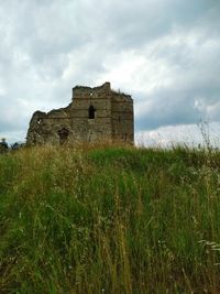 Old ruin building on field against sky