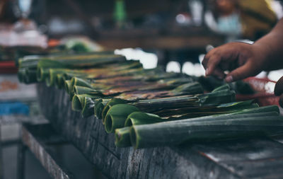 Cropped image of hand on selling leaves at market