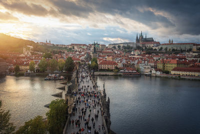 High angle view of townscape by river against sky during sunset