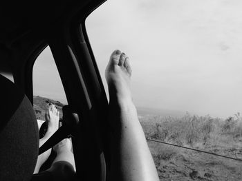 Low section of man on landscape against sky