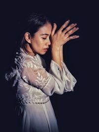 Midsection of woman standing against black background