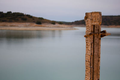 Close-up of wooden post against sky