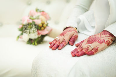 Henna tattoo on the bride's hand. heart shaped hand. with a wedding ring.